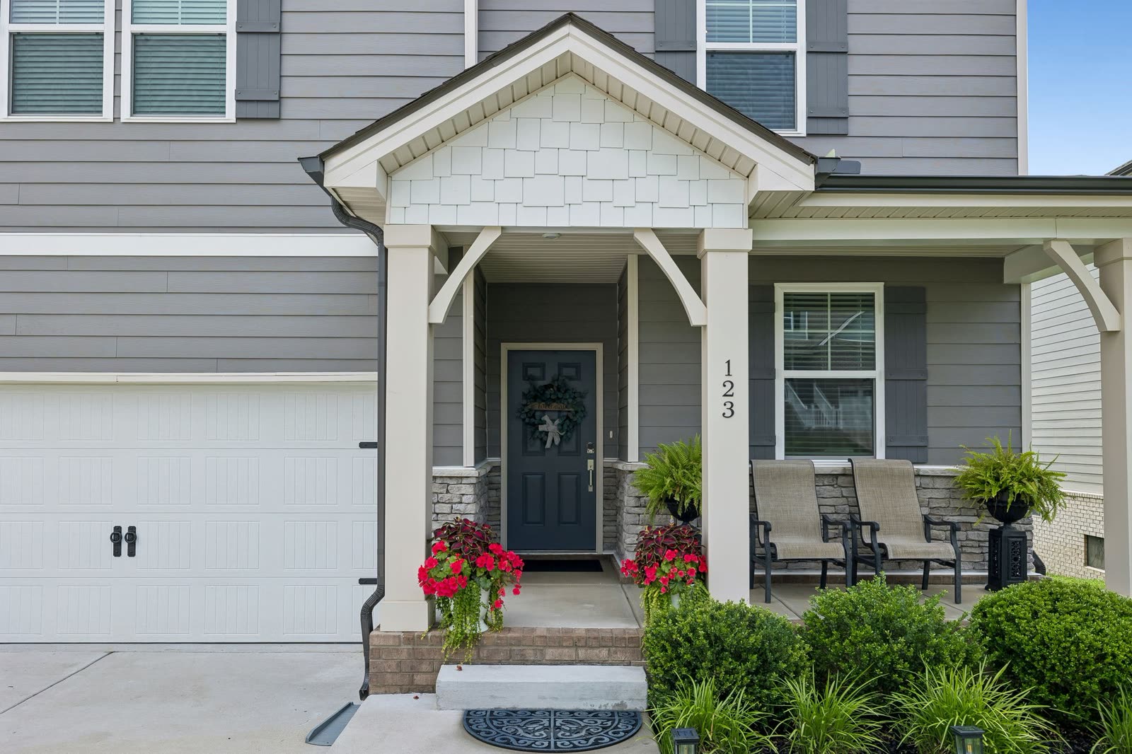 Covered front porch and navy front door at 123 Millbrook Drive